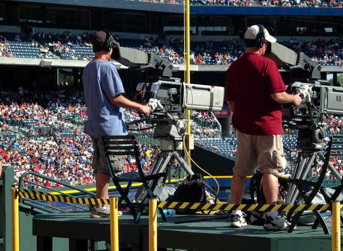 Sports broadcast camera operators filming a live match in a stadium